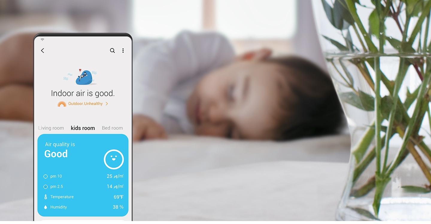 En el fondo hay un bebé durmiendo. En primer plano a la izquierda, está la pantalla de un dispositivo Galaxy que muestra la función SmartThings Air con el texto “El aire interior es bueno”. La calidad del aire de la sala indica “Bueno” junto con otros datos que se muestran abajo, incluidos los niveles de partículas, la temperatura y la humedad.