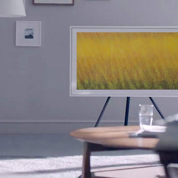 Se muestra una obra de arte de color amarillo en el televisor The Frame, el cual se encuentra en una habitación que se ilumina con la luz del sol.