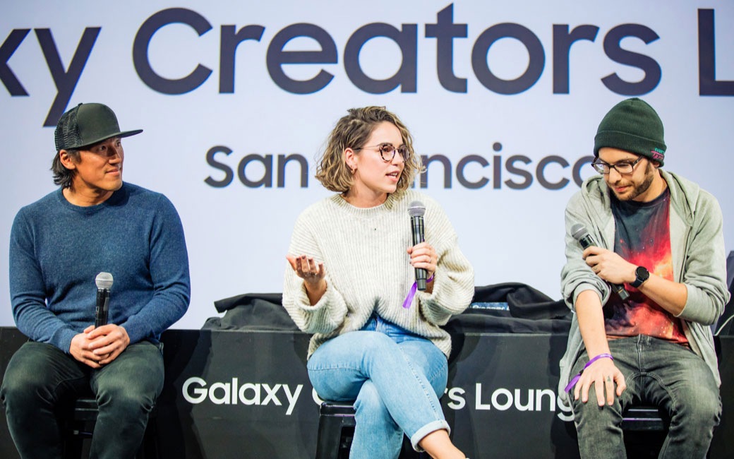 Los miembros del #EquipoGalaxy Jimmy Chin, Iz Harris y Jake Roper se encuentran en el salón de los creadores Creators Lounge durante la charla de los creadores. Iz Harris está en el medio y tiene el micrófono.