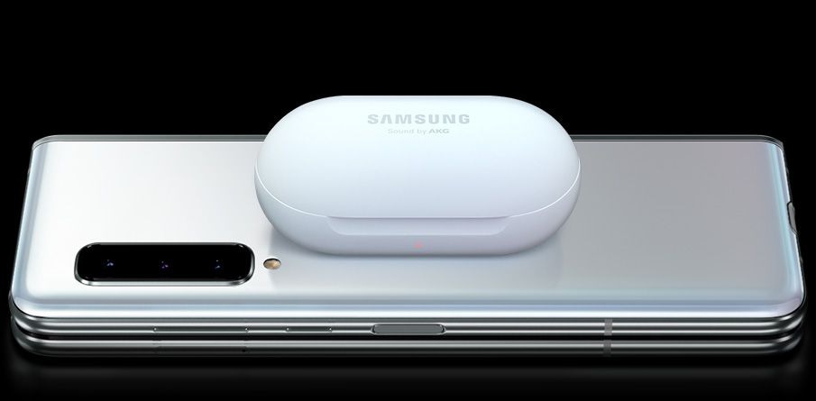 Des écouteurs Galaxy atterrissent sur l’arrière d’un Galaxy Fold plié, la partie supérieure s’ouvre et ils commencent à se recharger.