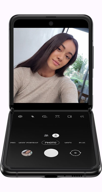Galaxy Z Flip plié en angle droit avec l'application Appareil photo ouverte à l'écran, démontrant comment s'adapte l'UX en fonction de l'angle d'ouvertur du téléphone.