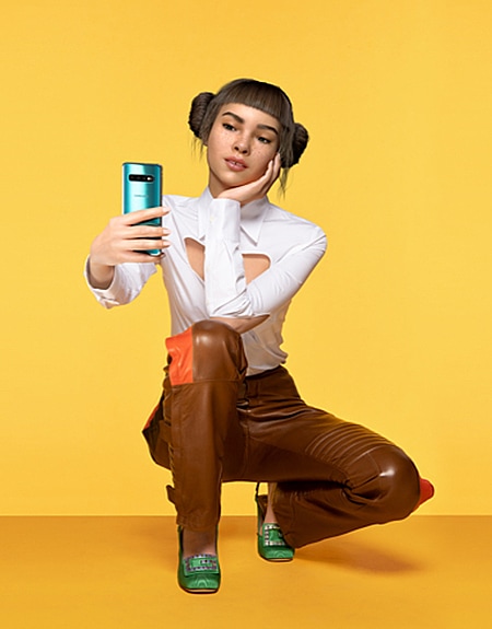 A full-body, promotional shot of Lil Miquela wearing a brightly coloured dress while looking confidently into the camera