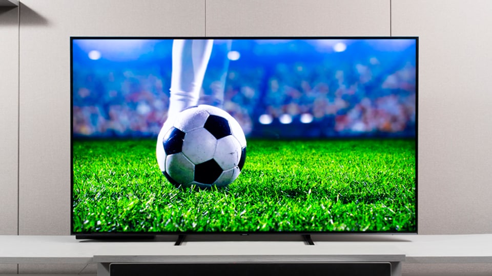 Samsung QLED TV with a scene of soccer game on screen