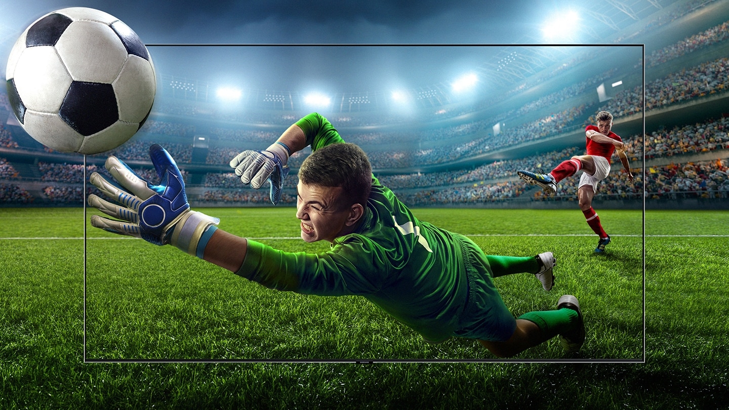 "A Samsung új 2018-as QLED TV-je, a háttérben és a képernyőn egy futball meccs jelenet látható egy labdáért vetődő kapussal."