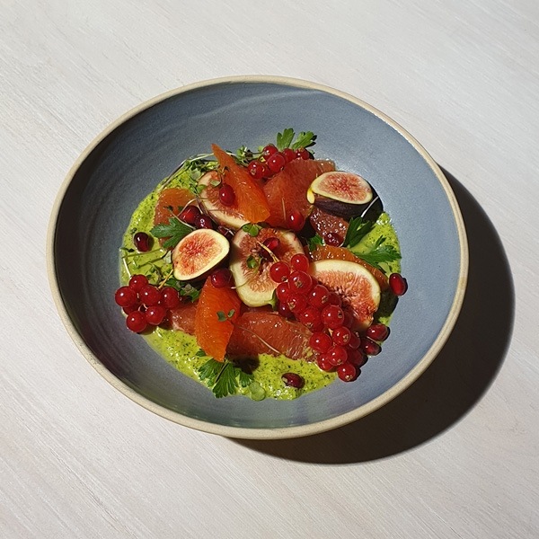 Uma foto tirada pelo Galaxy Note9 de uma tigela azul contendo um batido verde e frutos vermelhos