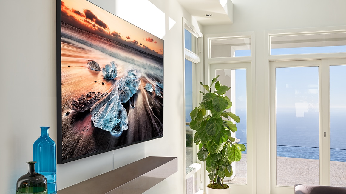  Una imagen lifestyle del nuevo Samsung QLED Q900R 2019. La imagen muestra el lateral del modelo Q900R colgado en la pared del salón.