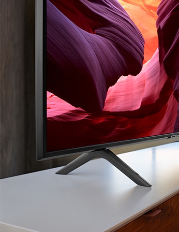 Primer plano del diseño del stand del nuevo Samsung QLED Q60R 2019. La imagen muestra el diseño elegante de la Q60R colocada en la mesa del televisor.