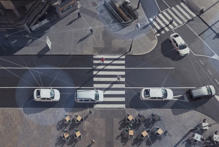 Aerial shot of a street scene with cars driving and people walking, with lines overlaid on top to show the connectivity of Wi-Fi and LTE. 