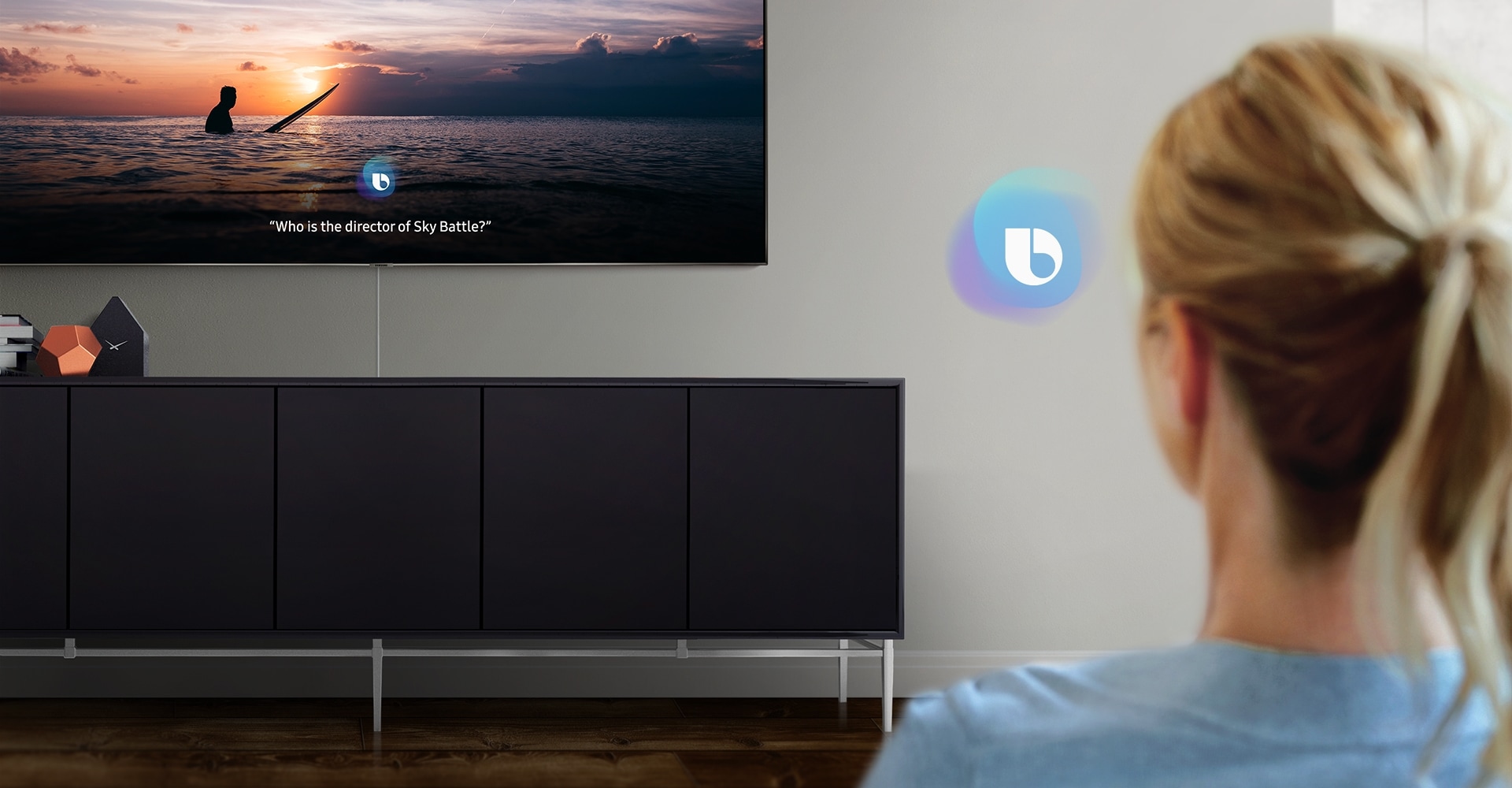 El televisor QLED de 2019 que muestra una pantalla en el modo Bixby de Samsung. Una mujer está hablando con el asistente de voz Bixby.