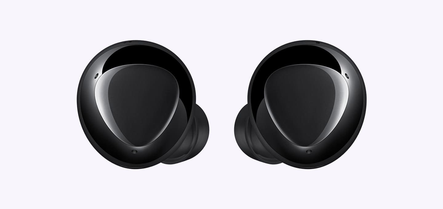 Un par de audífonos negros ampliados que muestran el diseño triangular en la superficie exterior.