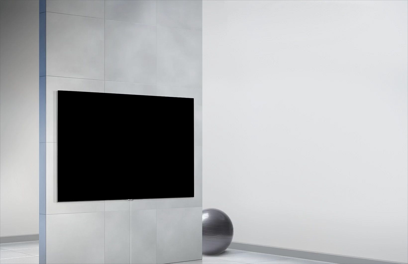 صورة تلفزيون مثبت على الحائط مع كرة تمرين على الأرض