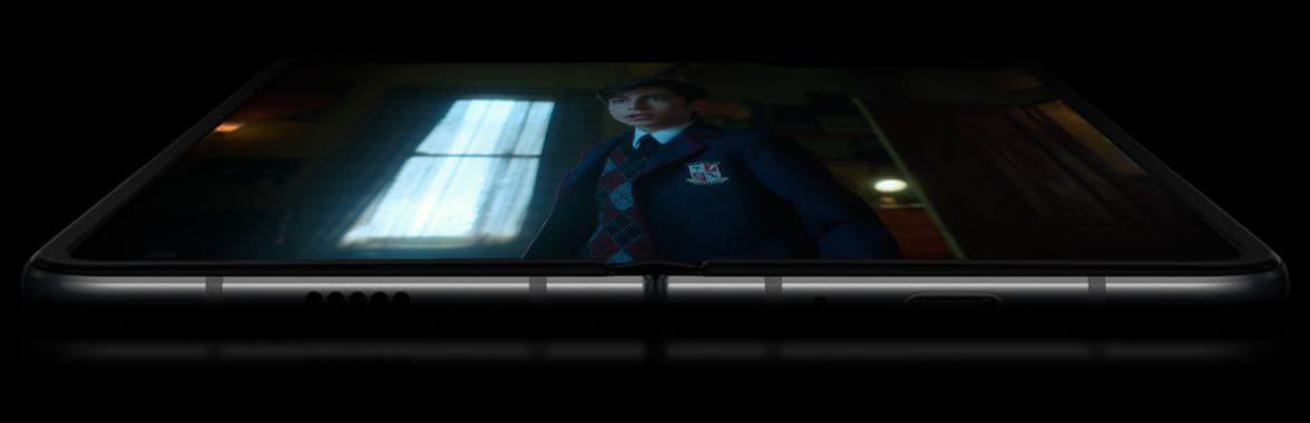 Galaxy Fold unfolded and laying face-up, with two batteries floating over each side of the screen. The display appears on top with a scene from Netflix Original Series The Umbrella Academy on-screen