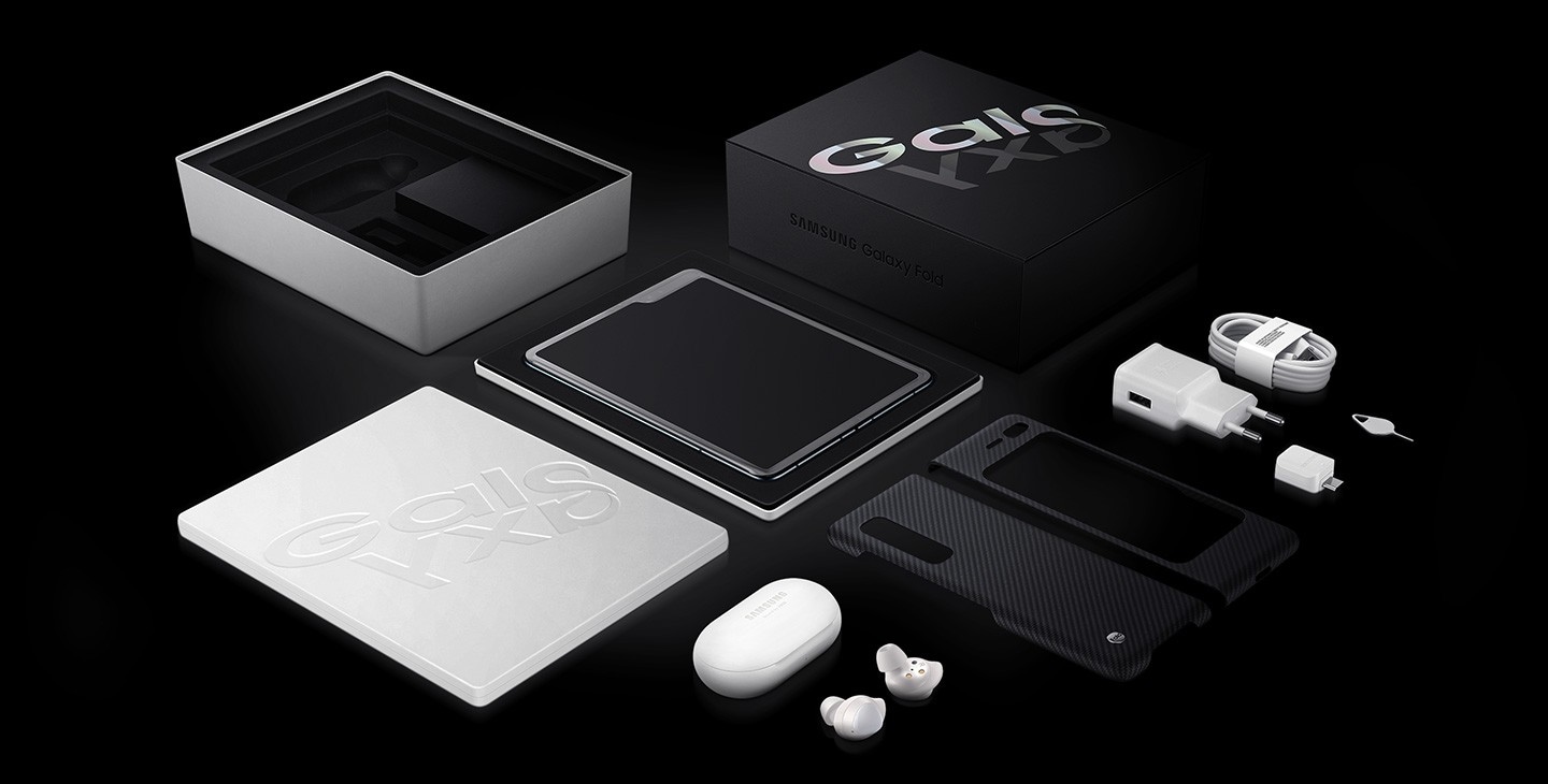 Flat lay photo of the Galaxy Fold box with Galaxy Fold. Below is the included Slim Cover, Galaxy Buds, Data Cable, Travel Adapter, Ejection Pin, and USB connector.