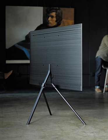 A lifestyle image of the 2018 new QLED TV Q7F. Image shows QLED TV put on the floor facing back, with its Studio Stand option.