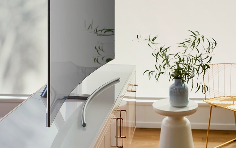 A lifestyle image of the 2018 new QLED TV Q8C. QLED TV is put on a table in the living room, shown in dynamic side angle.