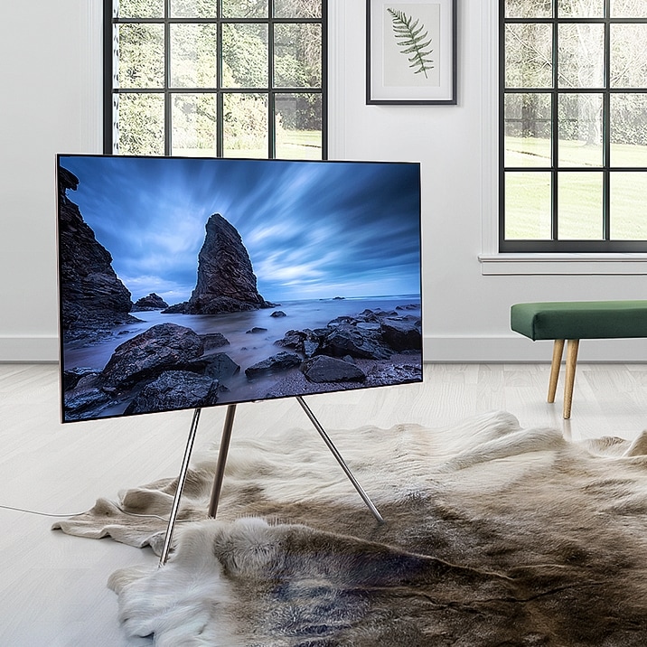 QLED TV standing with Studio stand in the middle of living room