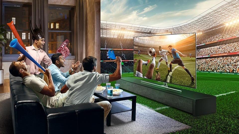 4 guys seating together excited watching soccer game on Samsung’s QLED TV