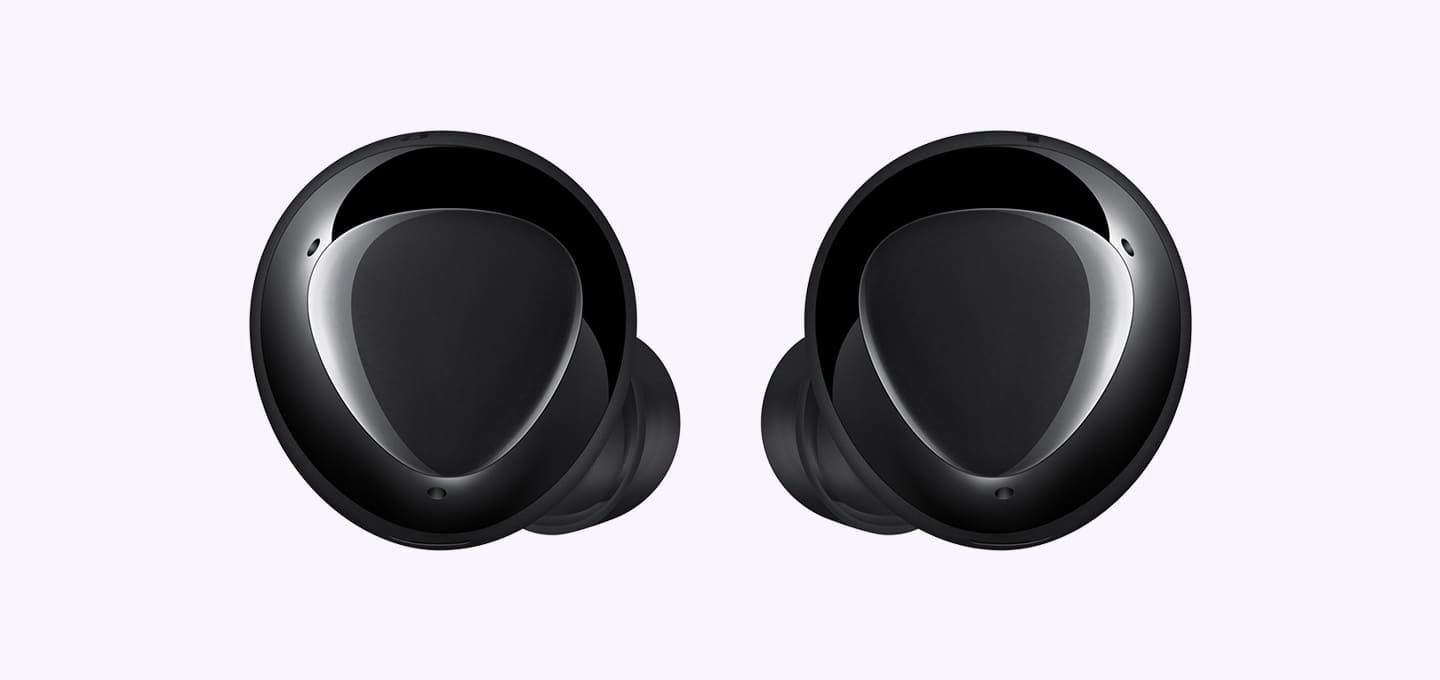 An enlarged pair of black earbuds displaying the triangular design on the outer surface.