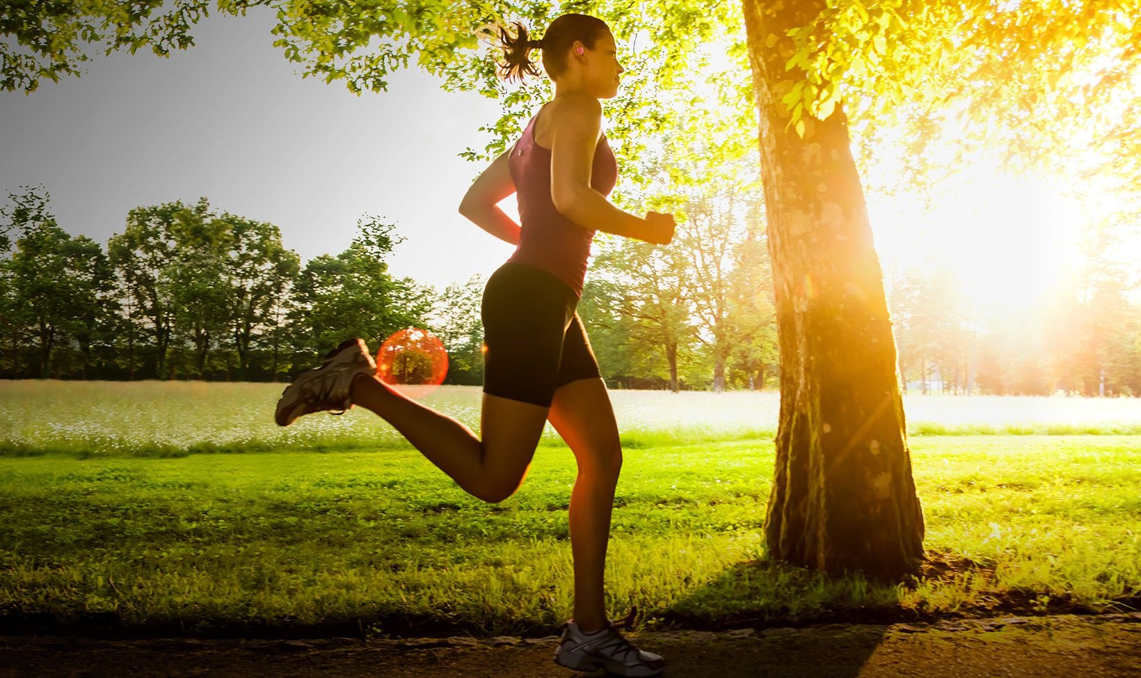 Background image of woman running in a park wearing Gear IconX