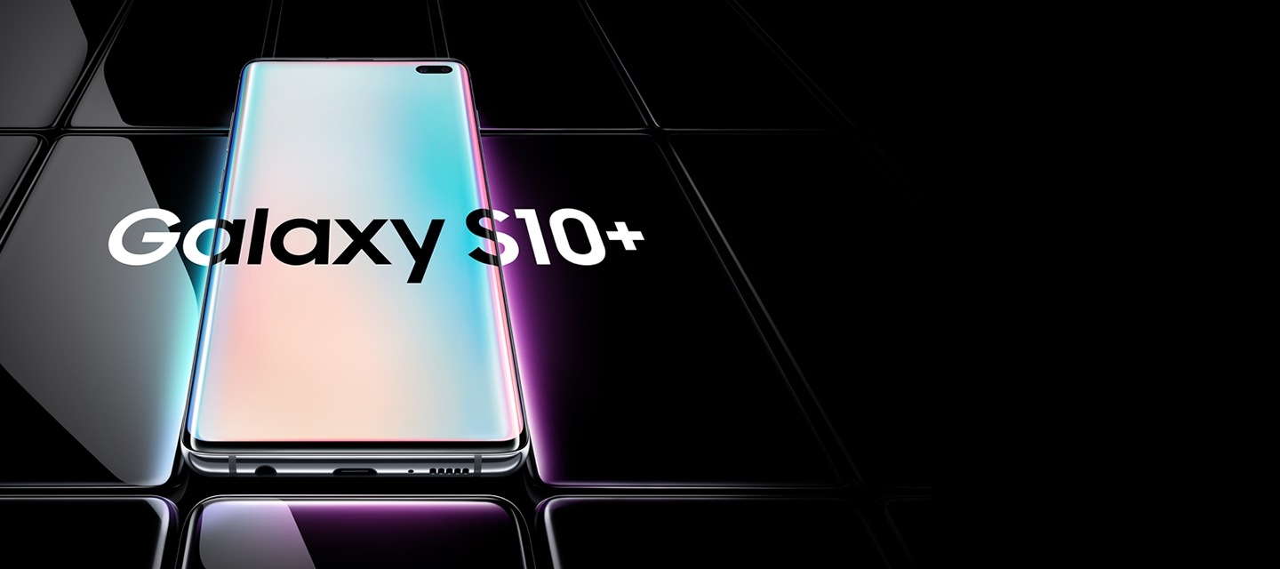Several Galaxy S10 plus phones all laid flat and seen at an angle from the bottom. All are black except the one in the middle, which is shown with a prismatic white gradient onscreen with Galaxy S10 plus overlaid on top of it and the two phones on either side.