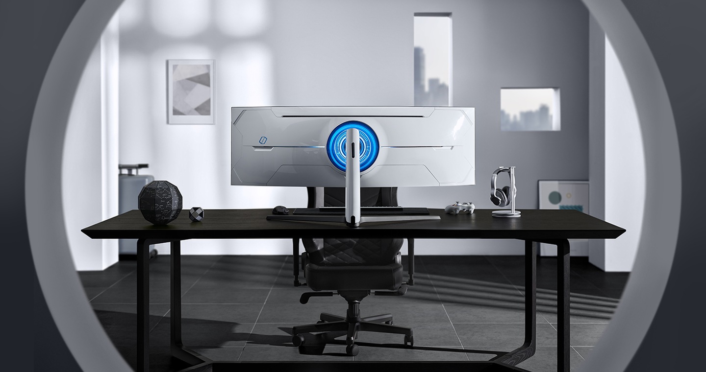 Widok z tyłu na zakrzywiony monitor Odyssey G9 - CTG9 o wyjątkowym nowoczesnym designie, który charakteryzuje się zaawansowanymi technologiami - monitor gamingowy Samsung Odyssey ustawiony na biurku znajdującym się w jednoosobowym gabinecie.