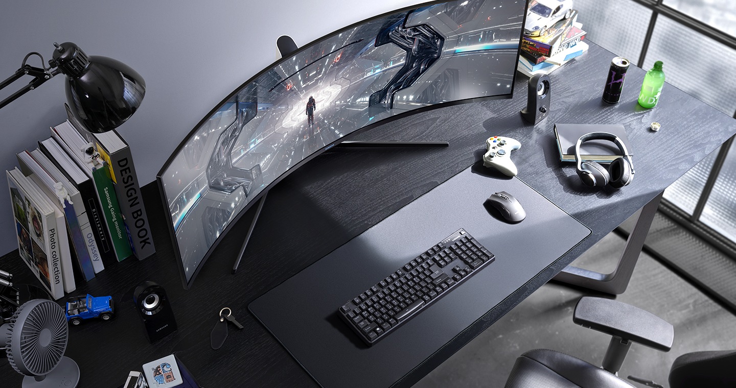 Dynamiczne ujęcie z góry przedstawiające zakrzywiony monitor Samsung G9 Odyssey ustawiony na biurku, na którym panuje nieład - zostań mistrzem rozgrywek, dzięki monitorowi Odyssey z technologią kropki kwantowej QLED.