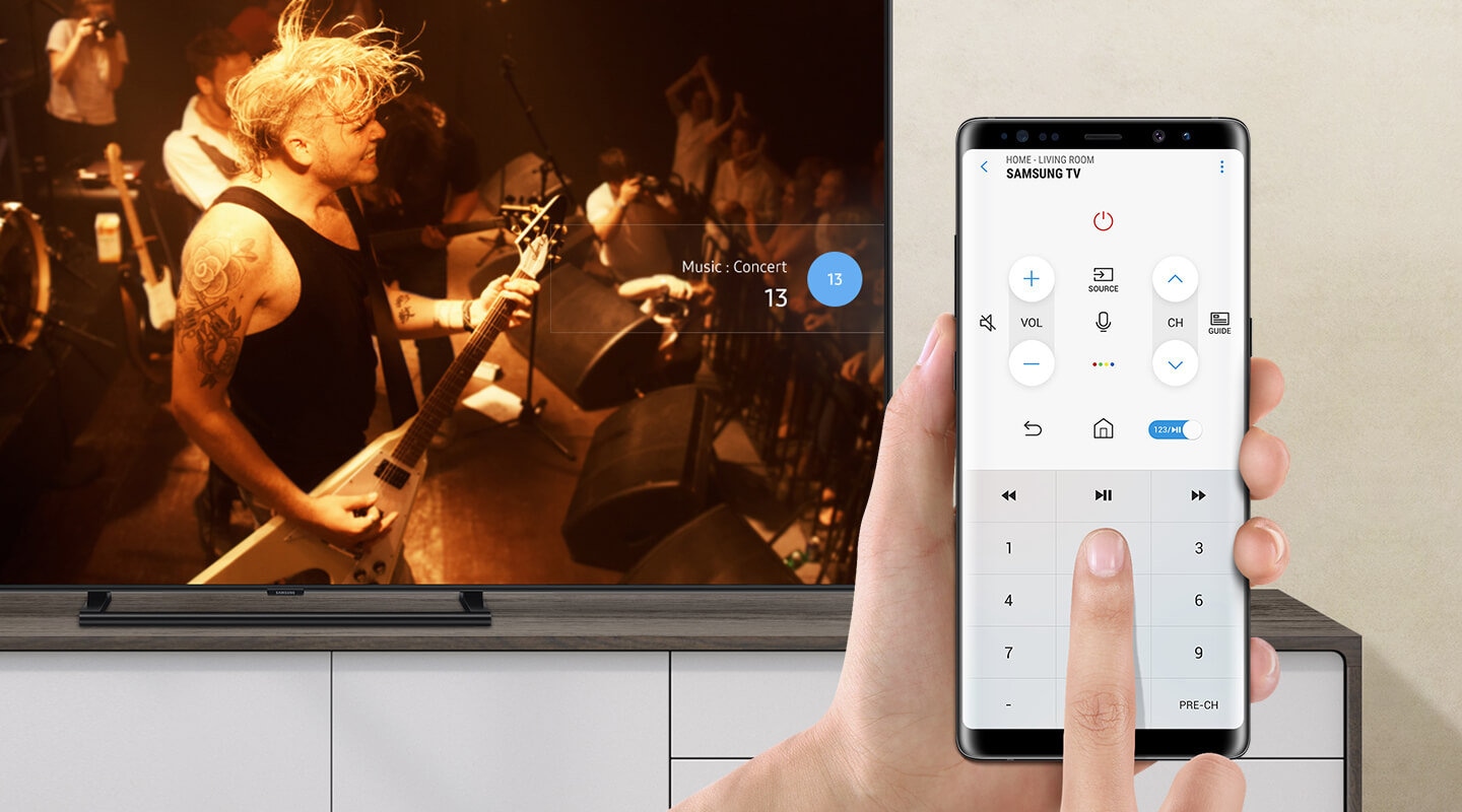 Remote control function on the mobile phone via SmartThings app. On the Smart TV screen, rock band is having a concert.