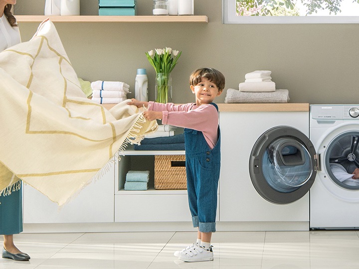 Uma criança a dobrar uma manta perto de uma Quickdrive