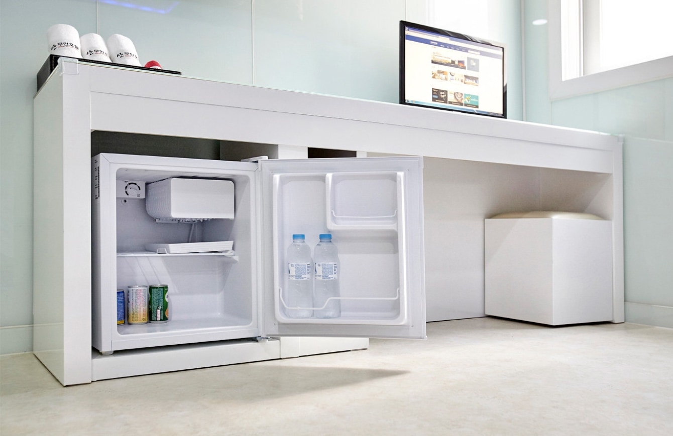 삼성PC가 설치된 테이블 아래 삼성 미니 냉장고 문이 열려져 있는 모습입니다.