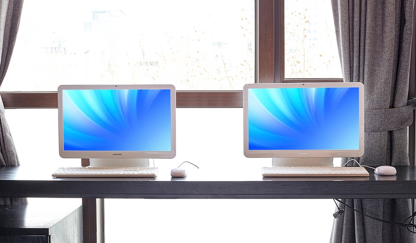 본체와 모니터가 하나로 합쳐진 삼성 올인원PC 두대가 나란히 책상 위에 놓여있는 사진