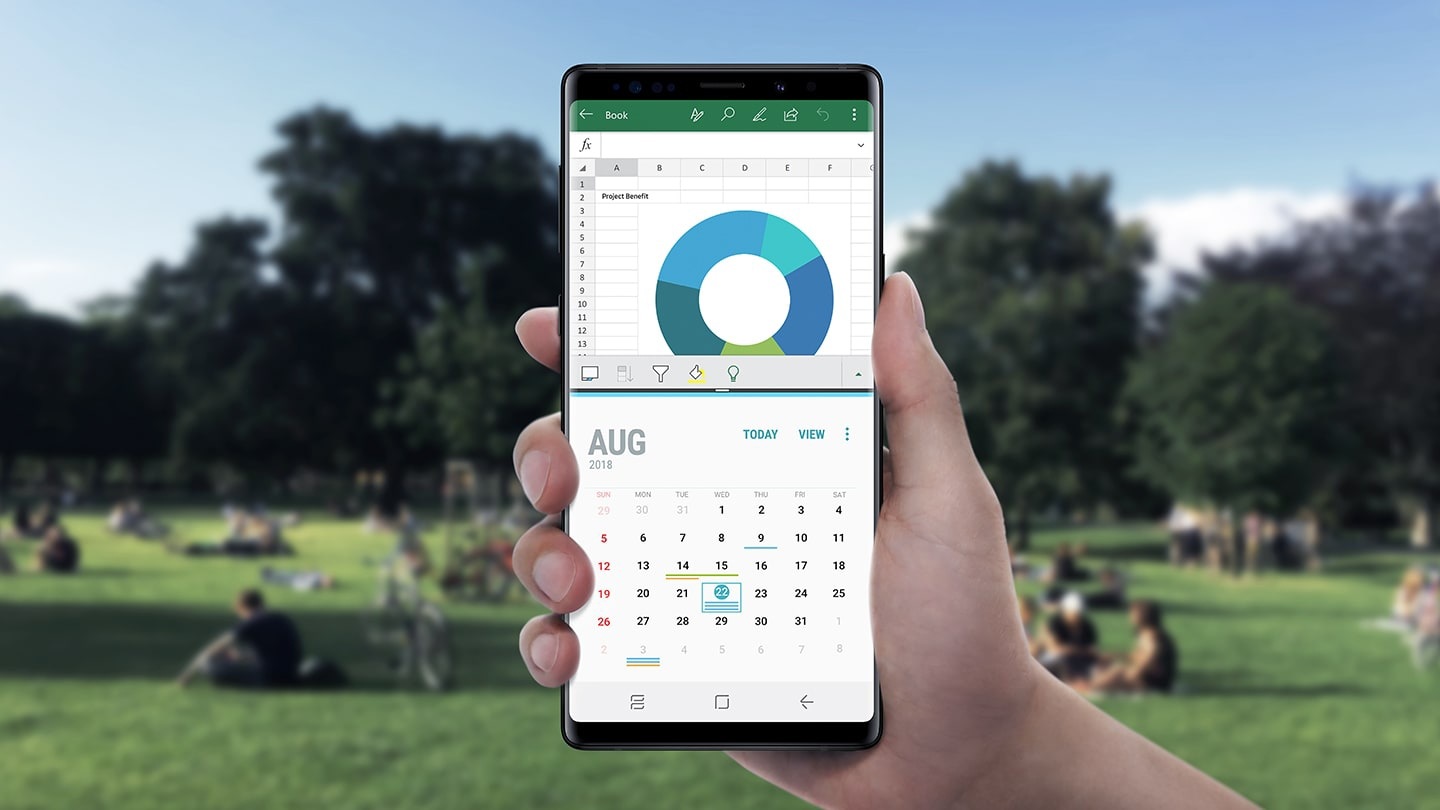 공원을 배경으로 디스플레이가 켜진 갤럭시 노트9인이 한손에 쥐어져 있습니다. 
