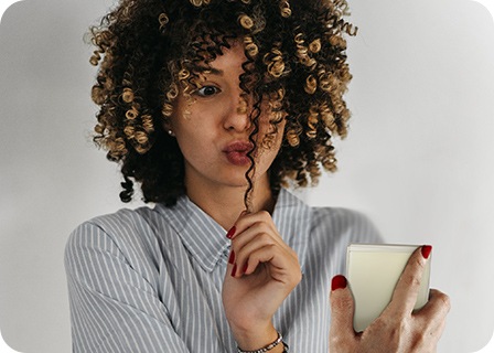 Une femme prend un selfie en regardant l’écran extérieur du Galaxy Z Flip3 plié.