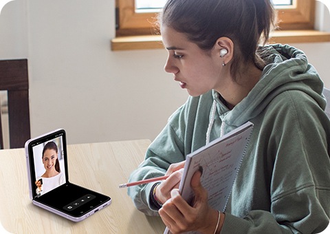 Une femme montre son livre à l’écran tout en effectuant un appel visio en Flex view.