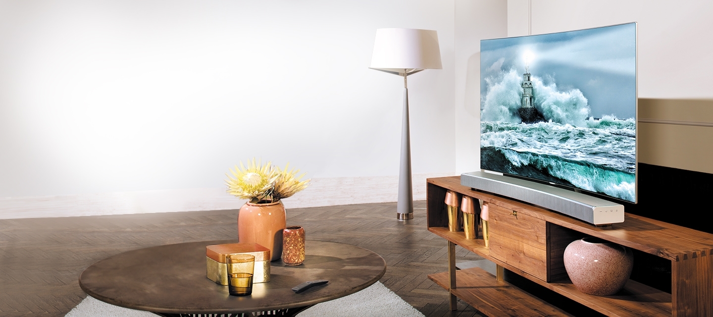 QLED TV와 사운드바가 연결되어 있는 모습입니다. 그 앞에 블루레이 플레이어와 옆으로는 무선 360 오디오의 모습이 보입니다.