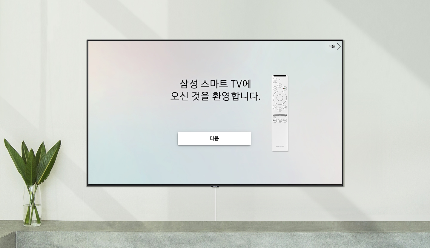 스마트 TV는 환영 스크린이 있는 벽에 배치되어 있습니다. 원격 제어 기능이 있는 "삼성 스마트 TV에 오신 것을 환영합니다."