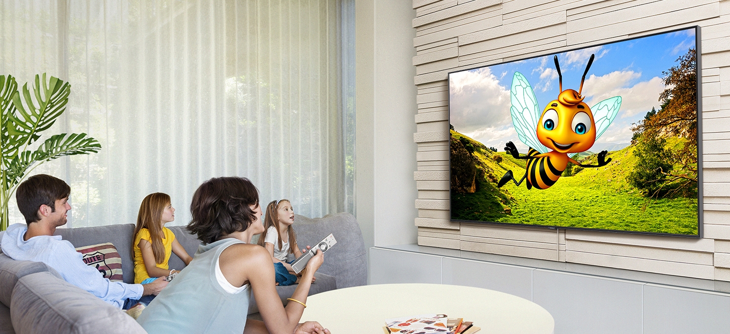 한 가족이 거실에서 삼성 스마트 TV로 유튜브를 보고 있습니다. 벌 캐릭터가 등장하는 3D 애니메이션이 스마트TV 유튜브 앱을 통해 스트리밍되고 있습니다.