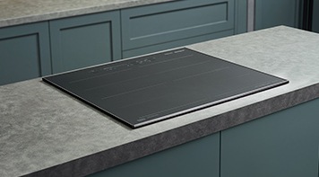 대리석으로 된 조리대 위에 전기레인지가 빌트인 방식으로 설치된 모습입니다.