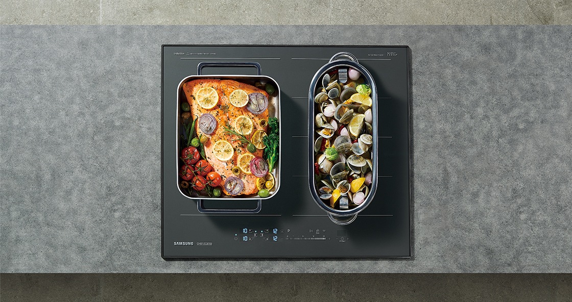 대리석으로 된 조리대 위에 전기레인지가 빌트인 방식으로 설치되어 있으며 이를 위에서 정면으로 내려다본 모습입니다. 전기레인지의 왼쪽 플렉스존에는 연어 스테이크, 오른쪽 플렉스존에는 조개찜을 조리중입니다.