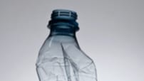 Close-up of plastic bottle seen slightly damaged.