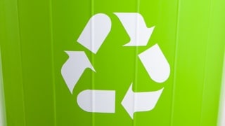 Recycling logo against a green background.