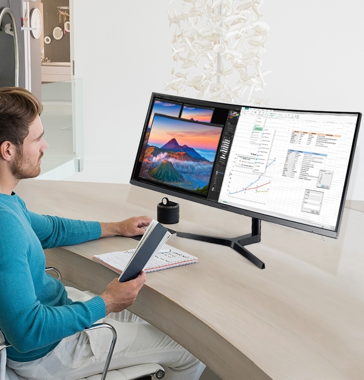 There is a table in the office, and you can see the man holding the mouse and book while he is looking at the segmented work screen.