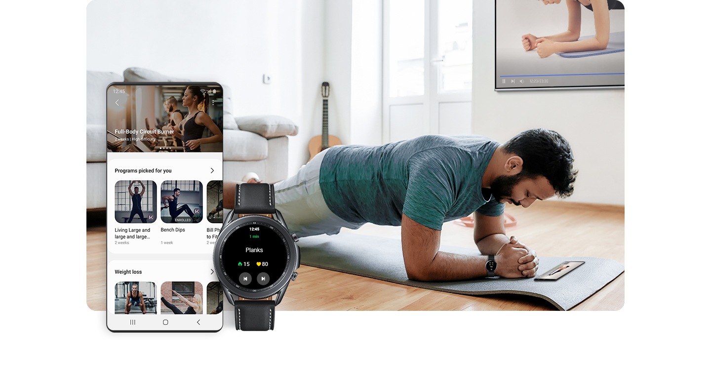 Galaxy smartphone displaying various fitness programs is shown with a Galaxy Watch showing the term "Planks" and duration time. Behind the smartphone and watch, a man wearing a smartwatch is shown performing a plank while watching a fitness video trainer on his smartphone.