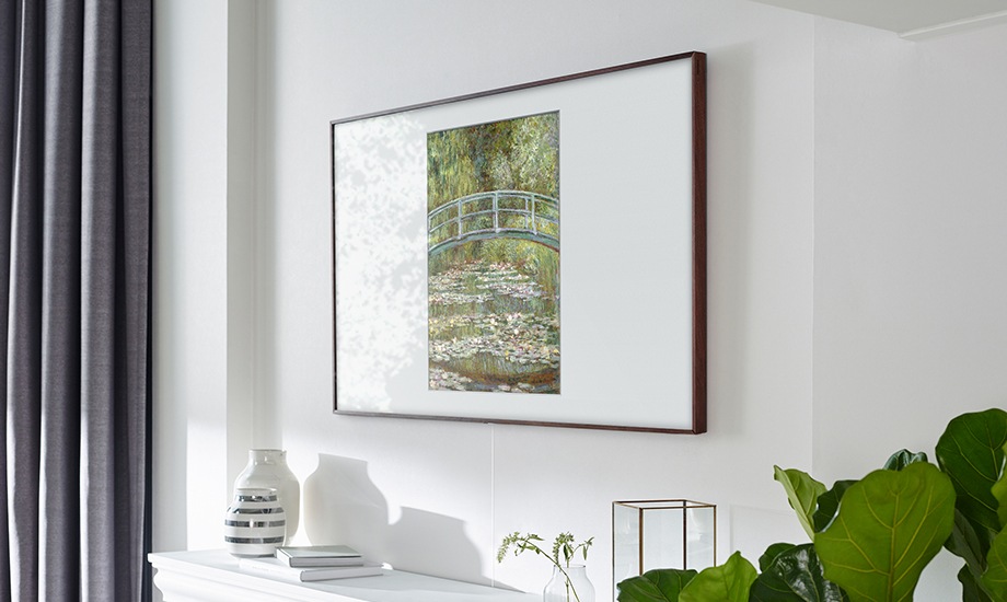 아트모드가 실행 중인 삼성 The Frame이 거실 벽에 걸려 있습니다. 화면엔 Claude Monet의 White Nenuphars가 보입니다. 흰색 톤의 거실 인테리어와 잘 어울립니다.