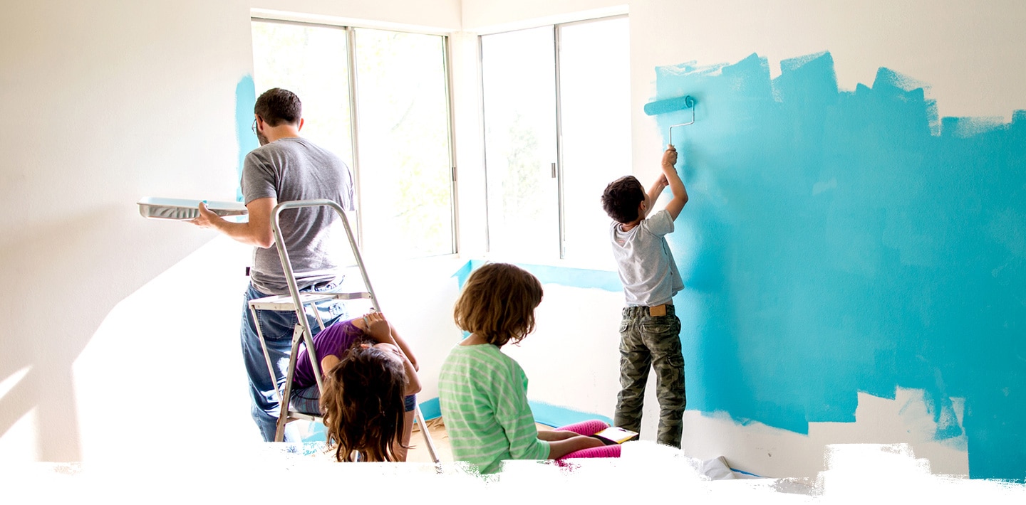 아빠와 세 명의 아이들이 집 안의 하얀 벽을 하늘색으로 칠하고 있습니다. 