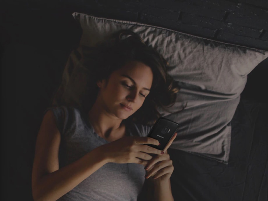 침대에 누워 갤럭시 노트8을 사용하고 있는 여성의 모습이 보입니다.