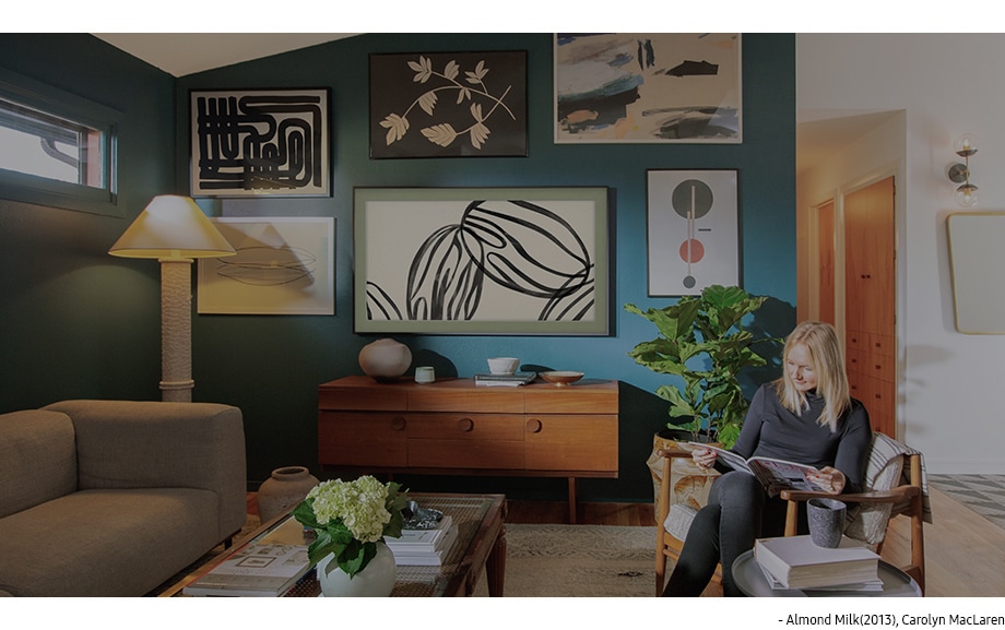 The Frame에 전시된 Carolyn MacLaren의 <Almond Milk> (2013) 포함해 다양한 작품들이 Kirste의 거실 벽에 걸려 있습니다.