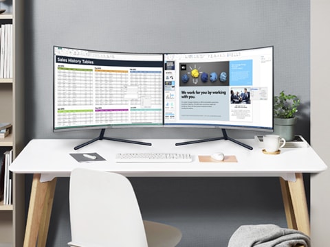 책상 위에 두 대의 삼성 모니터가 있습니다. 두 대의 모니터에 업무 관련 파일이 띄워져 있습니다.
