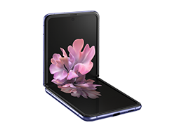 Galaxy Z Flip in Mirror Purple folded to a right angle, seen from the front with the blossoming flower graphic wallpaper on screen