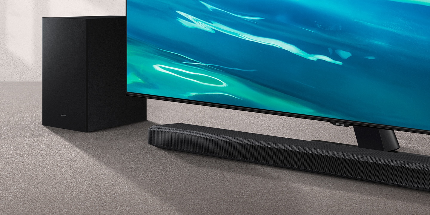 Q700A Soundbar and subwoofer are positioned next to QLED TV.