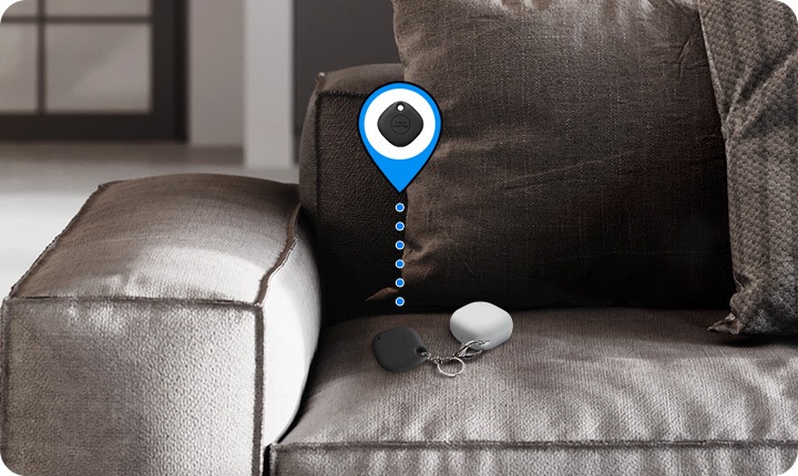 On a sofa, Galaxy Buds in the corner is seen with SmartTag+ attached. Virtual icon indicates that tag helps users find items.